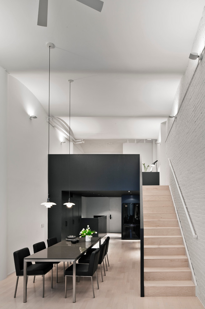 Imagen de comedor minimalista con paredes blancas y suelo de madera clara