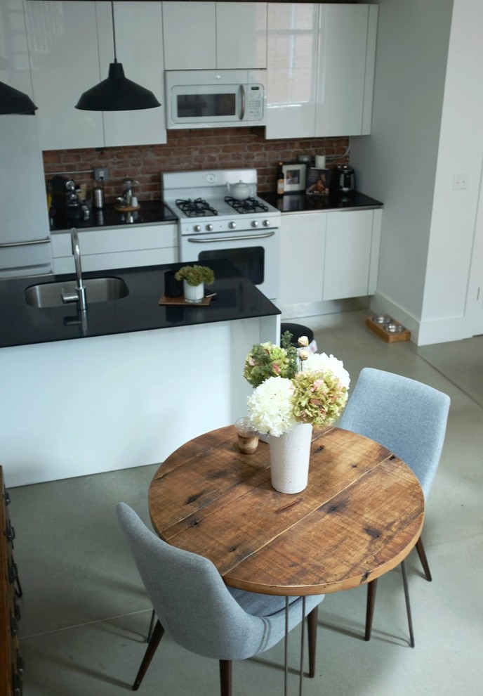 Cette photo montre une petite salle à manger industrielle avec sol en béton ciré et un sol gris.