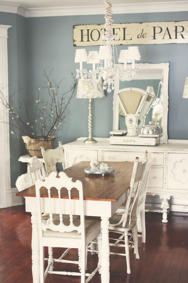 Idée de décoration pour une salle à manger style shabby chic avec un mur bleu, parquet foncé et éclairage.