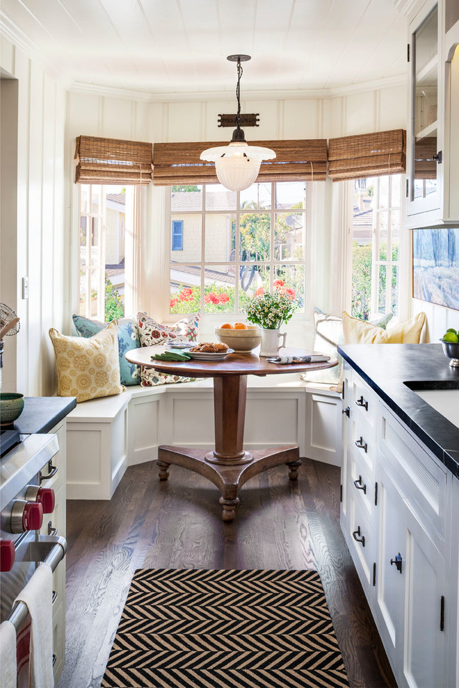 Idee per una piccola sala da pranzo aperta verso la cucina classica con pareti bianche, parquet scuro e pavimento marrone