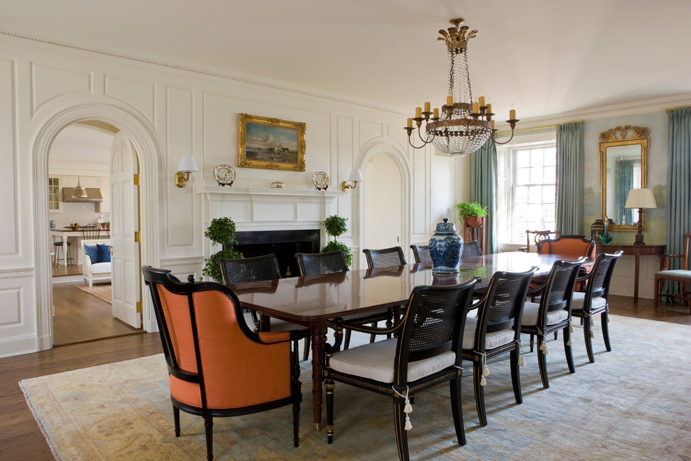 Aménagement d'une salle à manger classique avec un mur blanc, parquet foncé et une cheminée standard.