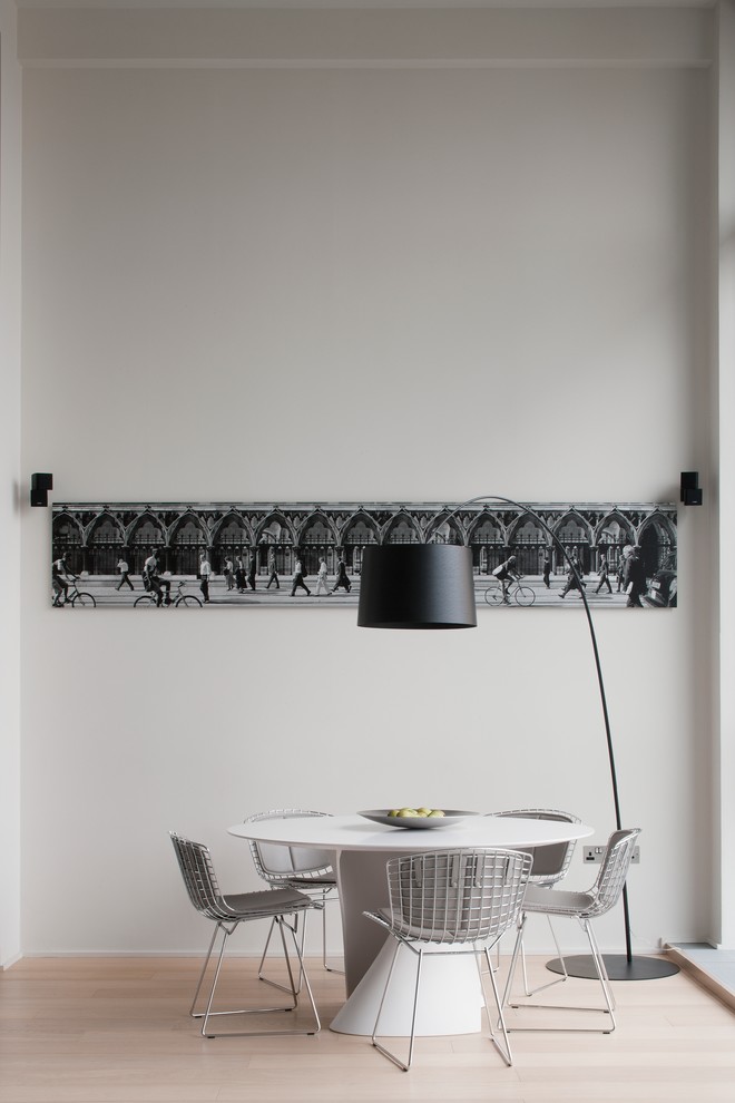 Imagen de comedor contemporáneo con paredes blancas y suelo de madera clara