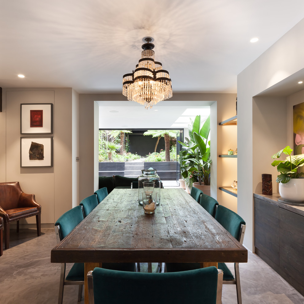 Immagine di una sala da pranzo aperta verso il soggiorno minimal di medie dimensioni con pareti bianche, pavimento in cemento e pavimento grigio