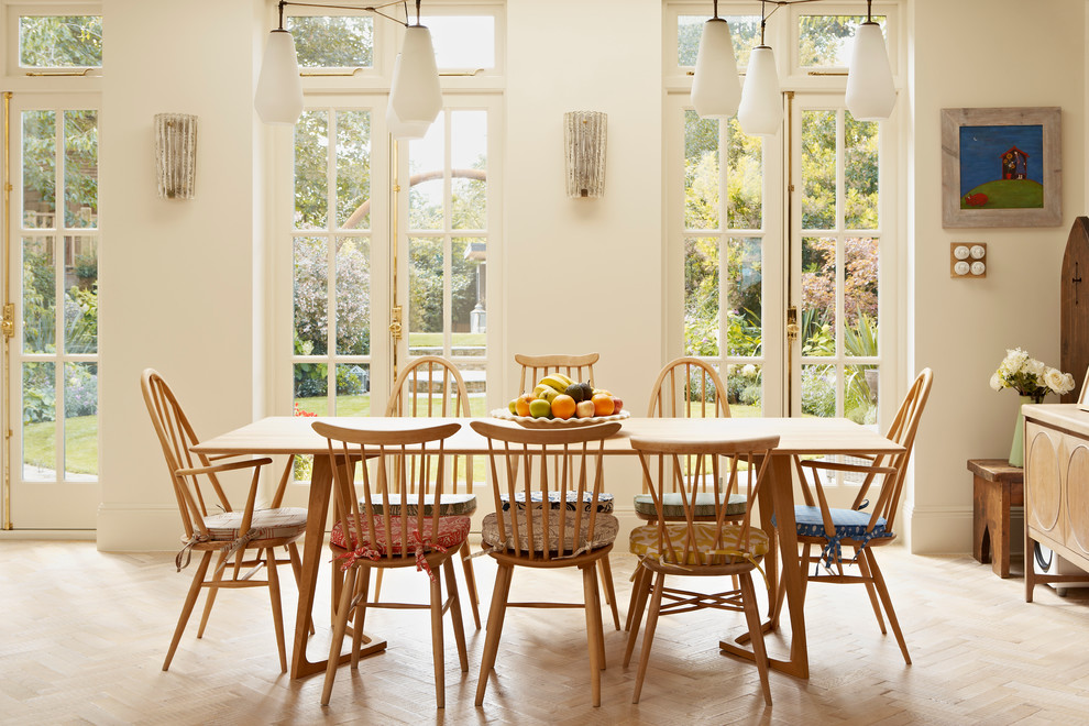 Inspiration for a country dining room in London with white walls and light hardwood flooring.