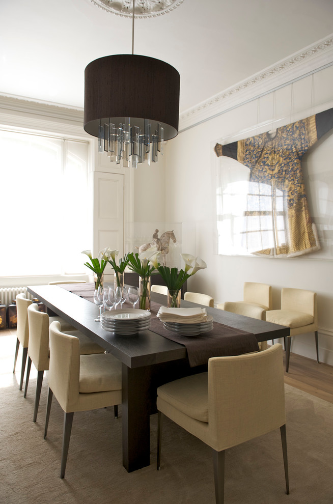 Large contemporary open plan dining room in London with white walls and medium hardwood flooring.