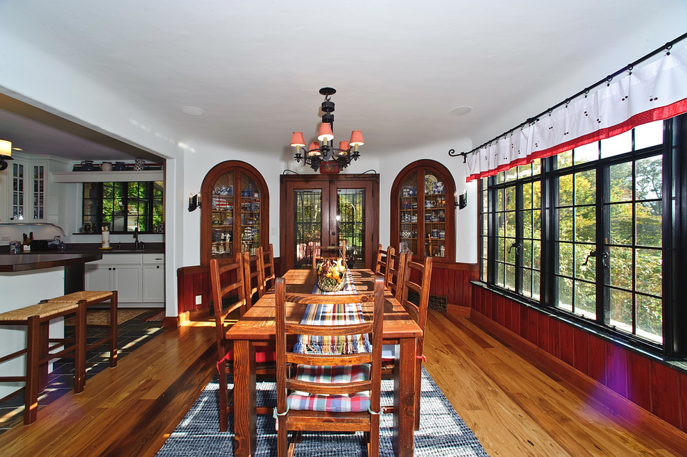 Imagen de comedor de cocina tradicional con paredes blancas y suelo de madera en tonos medios