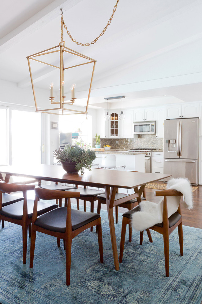 Ispirazione per una sala da pranzo aperta verso la cucina minimalista di medie dimensioni con pareti bianche, parquet scuro, camino classico e cornice del camino piastrellata