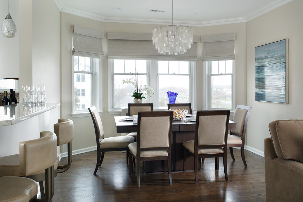 Immagine di una sala da pranzo aperta verso il soggiorno tradizionale con pareti beige e parquet scuro
