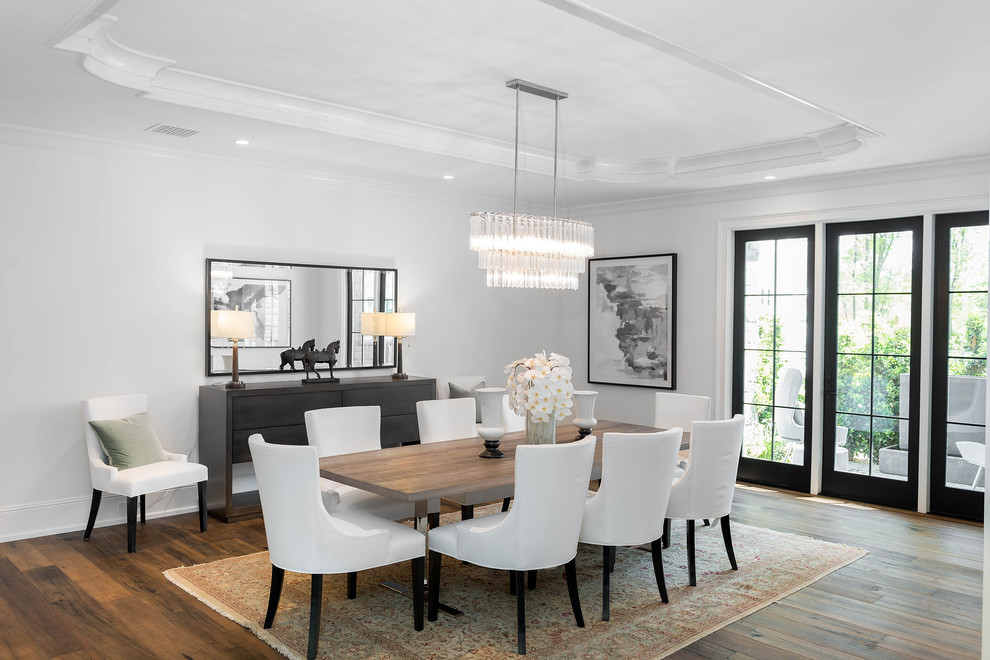 Example of a transitional brown floor and medium tone wood floor dining room design in Los Angeles with white walls