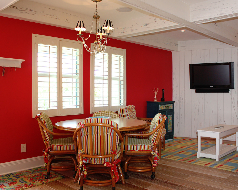 Cette image montre une salle à manger ouverte sur le salon marine de taille moyenne avec un mur rouge, parquet clair et aucune cheminée.