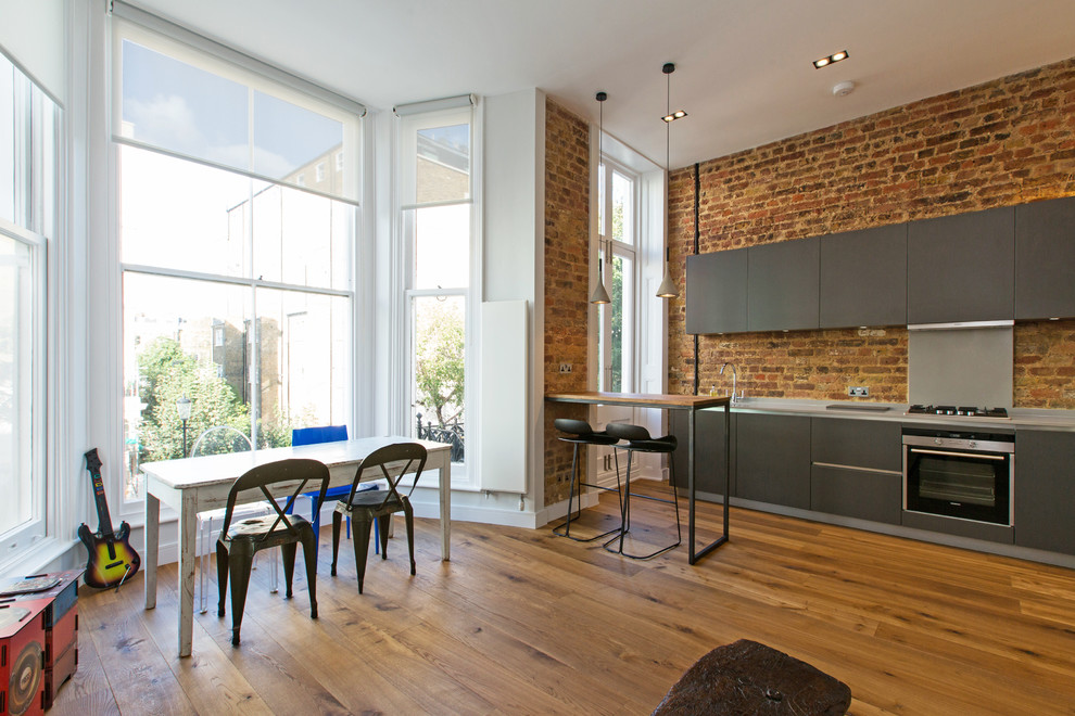 Cette image montre une salle à manger ouverte sur la cuisine design de taille moyenne avec un sol en bois brun et un mur blanc.