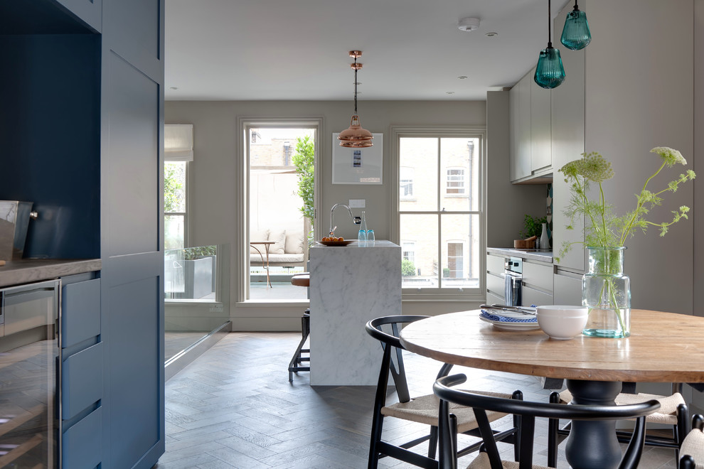 Immagine di una sala da pranzo aperta verso la cucina design con pareti bianche e parquet scuro