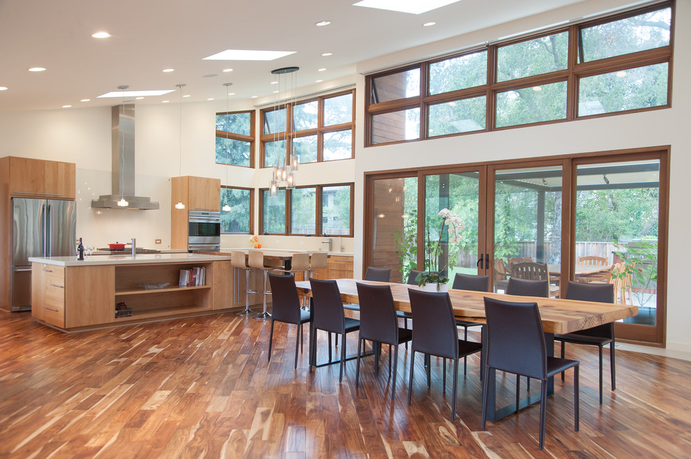 Ispirazione per una sala da pranzo aperta verso il soggiorno contemporanea con pareti bianche e pavimento in legno massello medio