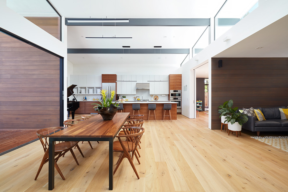 Esempio di una sala da pranzo aperta verso il soggiorno moderna con parquet chiaro