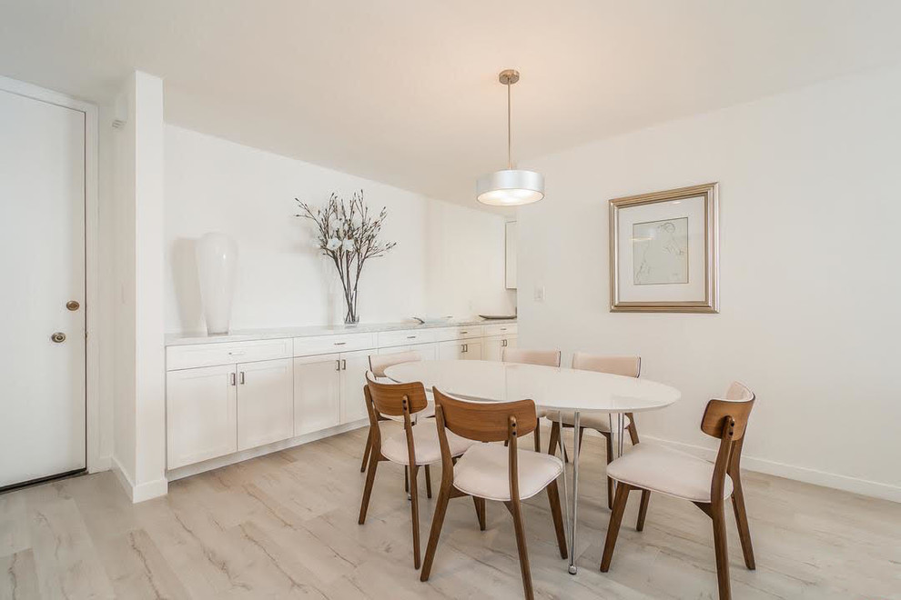 Cette photo montre une salle à manger ouverte sur le salon tendance de taille moyenne avec un mur blanc, parquet clair, aucune cheminée et un sol beige.