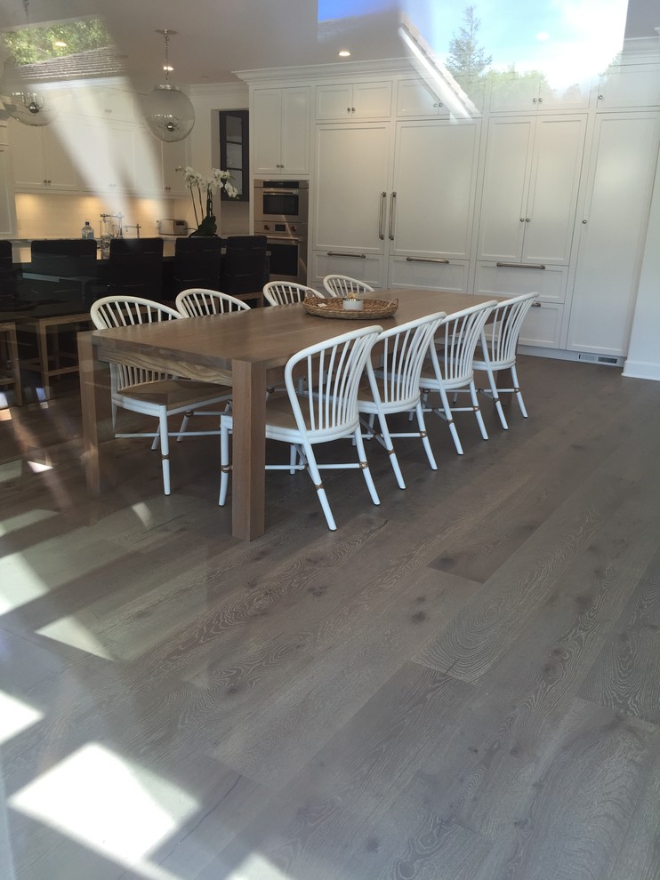 Photo of a large beach style kitchen/dining room in Los Angeles with white walls, dark hardwood flooring and no fireplace.