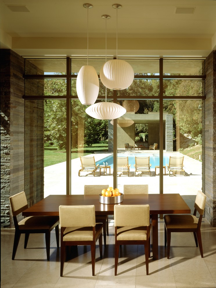 Esempio di una sala da pranzo aperta verso la cucina minimalista con pavimento in pietra calcarea