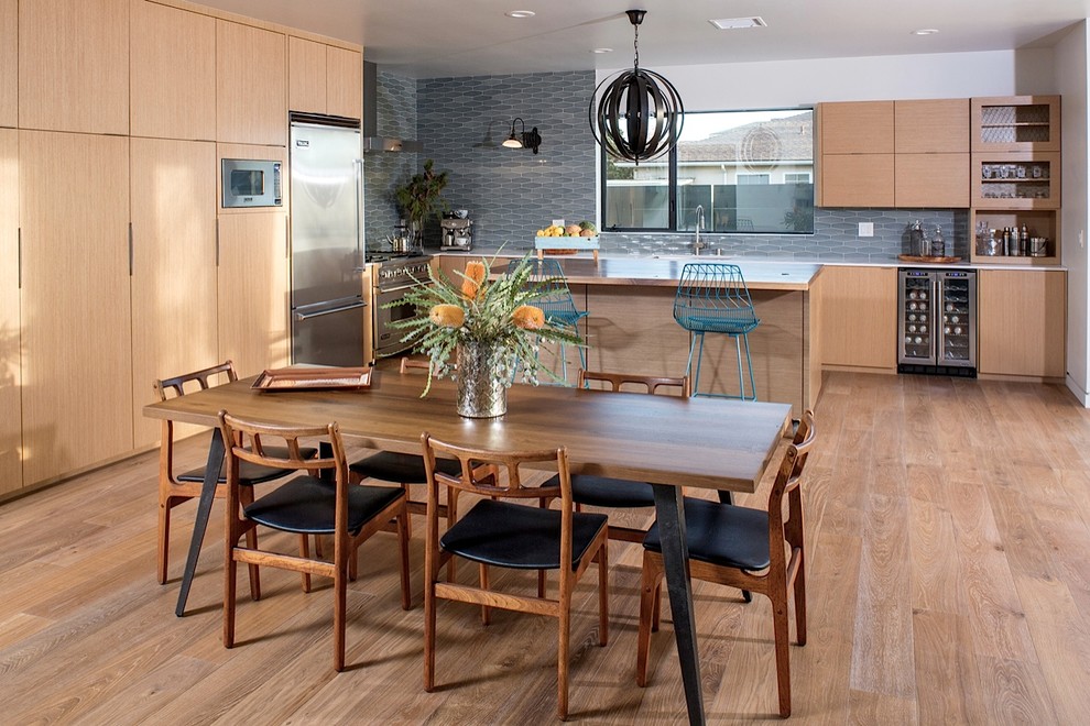 Moderne Wohnküche mit weißer Wandfarbe und braunem Holzboden in Los Angeles