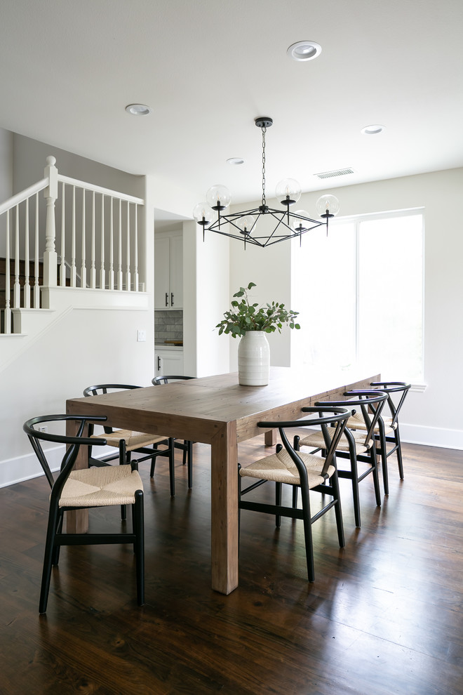 This is an example of a beach style dining room in Orange County with white walls, dark hardwood flooring and brown floors.
