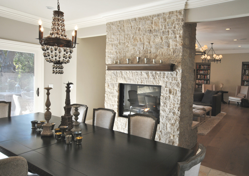 Photo of a small classic open plan dining room in San Francisco with grey walls, medium hardwood flooring, a two-sided fireplace, a stone fireplace surround and brown floors.