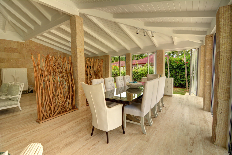 Beach style open plan dining room in Other with beige walls and feature lighting.