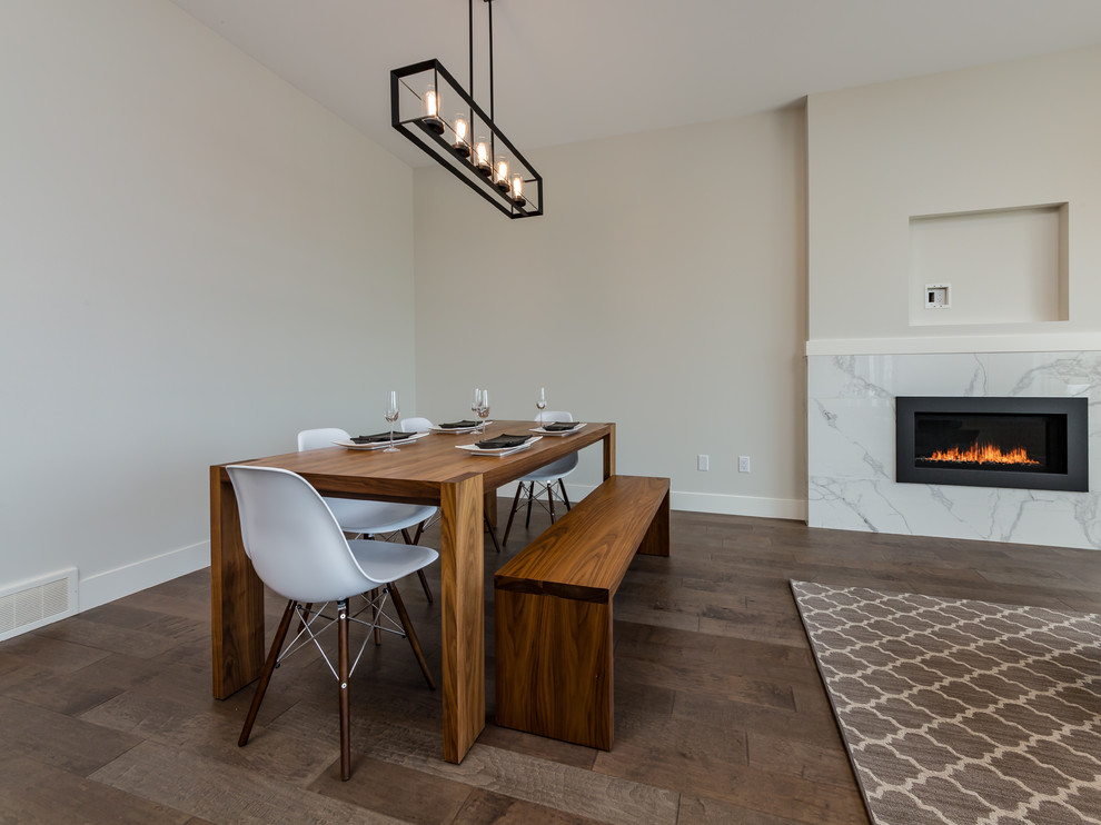 Cette image montre une salle à manger ouverte sur la cuisine marine de taille moyenne avec un sol en bois brun, une cheminée standard, un manteau de cheminée en carrelage, un sol marron et un mur beige.