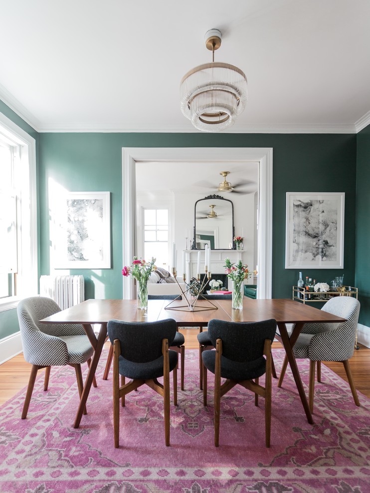 Aménagement d'une salle à manger classique fermée avec un mur vert, un sol en bois brun et un sol marron.