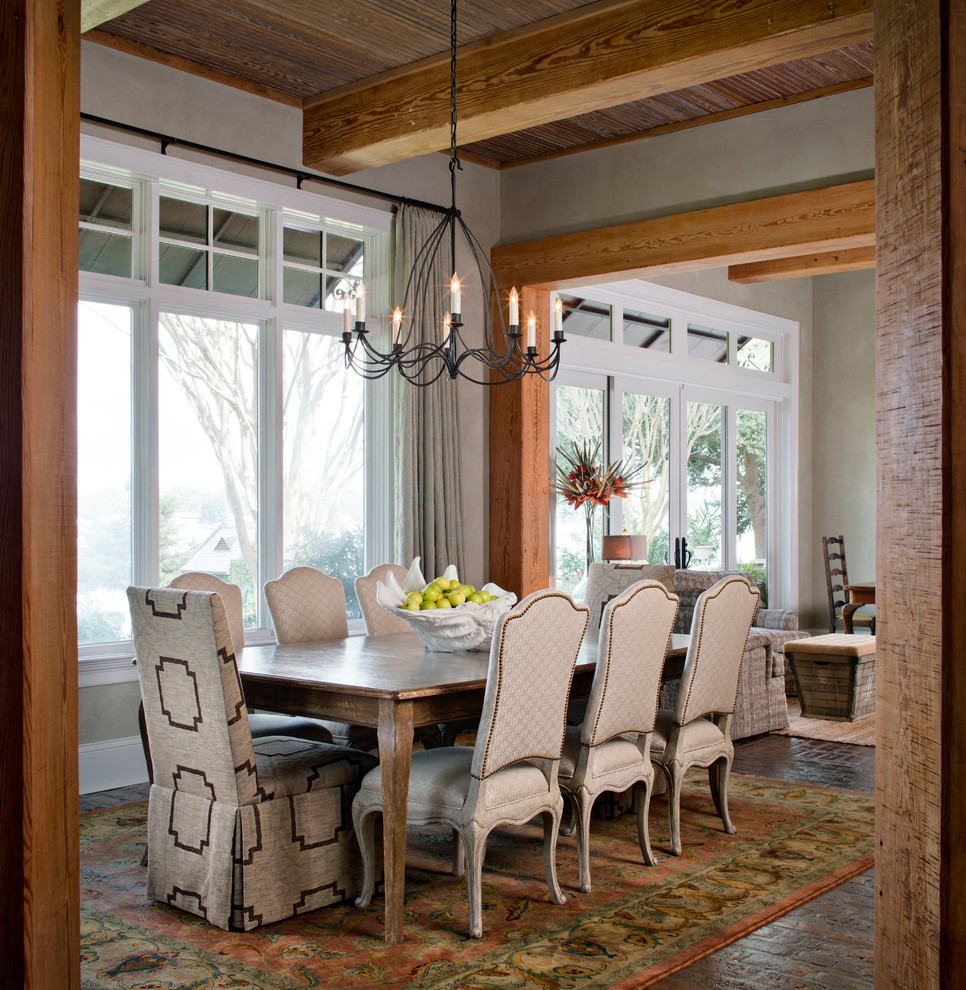 Inspiration pour une salle à manger ouverte sur le salon chalet de taille moyenne avec un mur gris et un sol en brique.