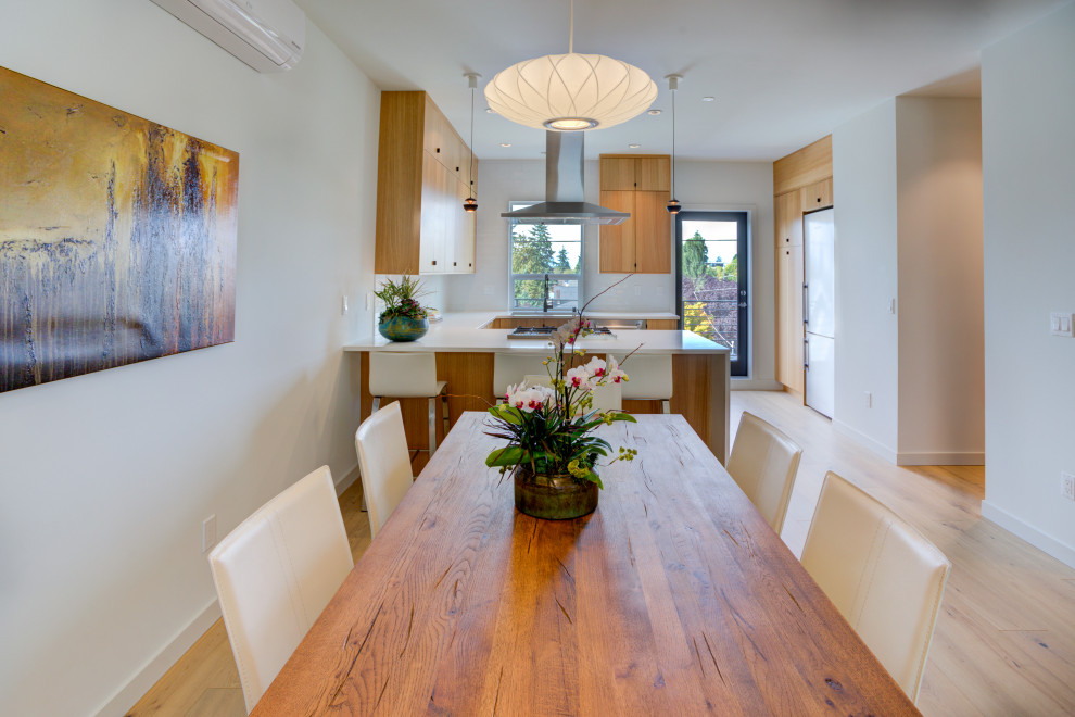 Example of a mid-sized minimalist light wood floor kitchen/dining room combo design in Seattle with white walls