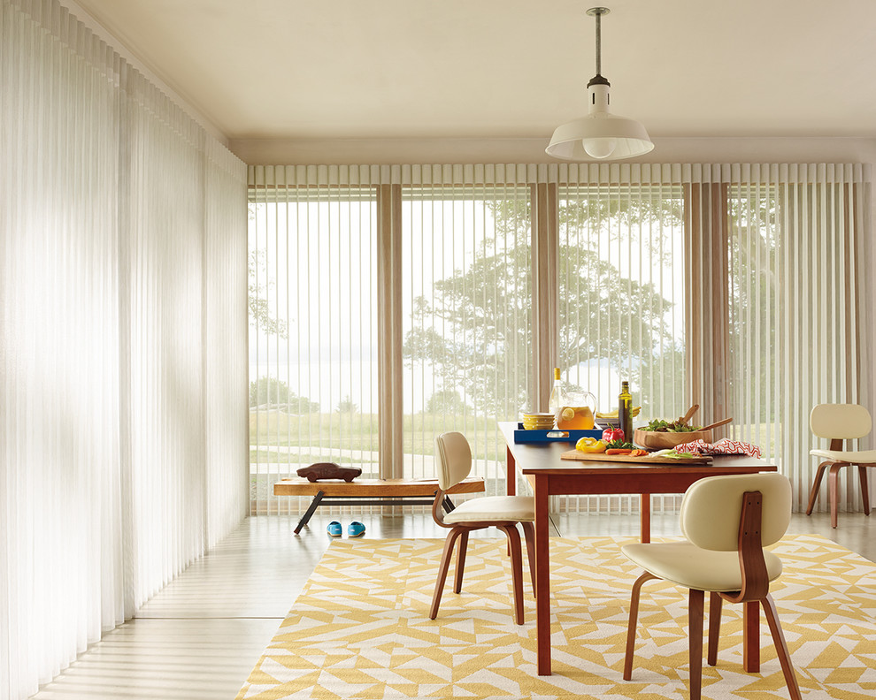 Immagine di una grande sala da pranzo aperta verso il soggiorno moderna con pareti bianche e pavimento in pietra calcarea