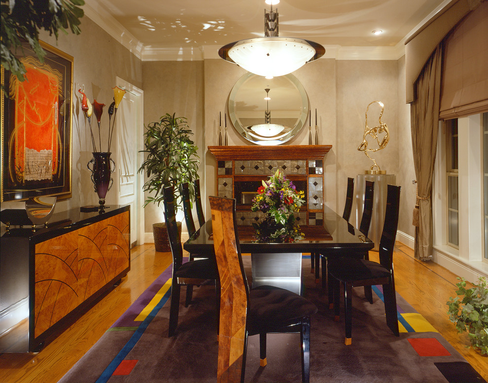 Immagine di una sala da pranzo contemporanea con pareti beige, pavimento in legno massello medio, camino classico e cornice del camino piastrellata