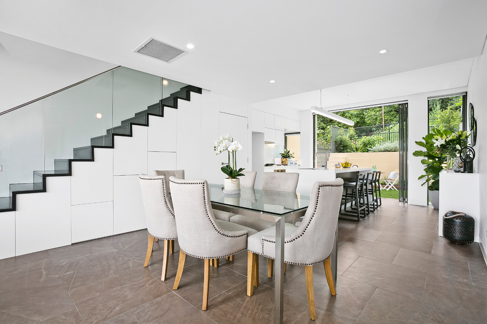 Immagine di una sala da pranzo aperta verso il soggiorno minimal di medie dimensioni con pareti bianche e pavimento con piastrelle in ceramica