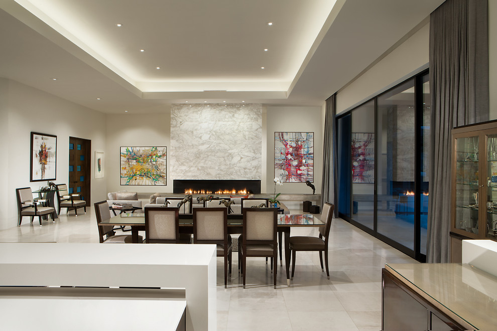 Réalisation d'une salle à manger ouverte sur le salon design de taille moyenne avec un mur blanc, une cheminée ribbon, un manteau de cheminée en pierre, un sol en marbre et un sol blanc.