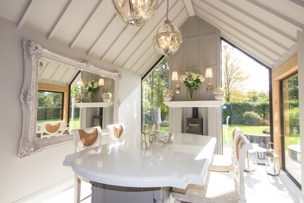 Idée de décoration pour une salle à manger champêtre de taille moyenne avec un mur beige, parquet clair et un poêle à bois.