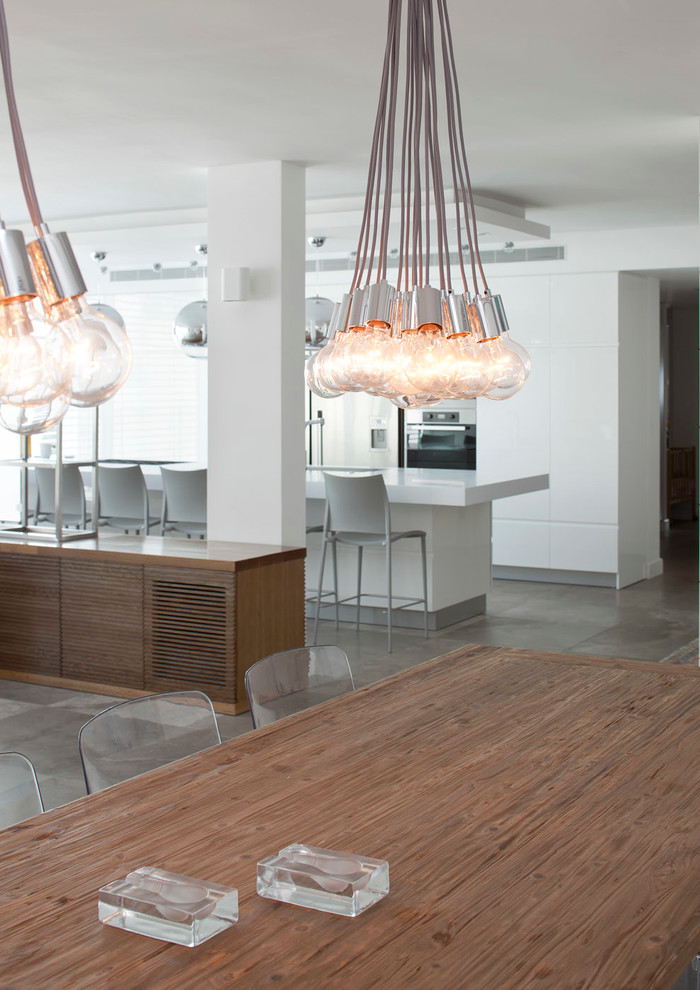 Ispirazione per una sala da pranzo aperta verso la cucina contemporanea di medie dimensioni con pareti bianche e pavimento in pietra calcarea
