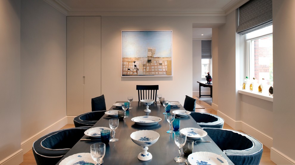 Inspiration for a medium sized contemporary dining room in London with white walls and medium hardwood flooring.