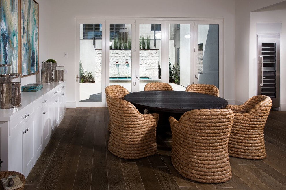 Immagine di una sala da pranzo aperta verso il soggiorno stile marinaro di medie dimensioni con pareti bianche, parquet scuro e pavimento marrone