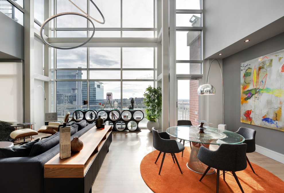 На фото: гостиная-столовая среднего размера в стиле модернизм с серыми стенами, светлым паркетным полом, стандартным камином, фасадом камина из плитки и серым полом