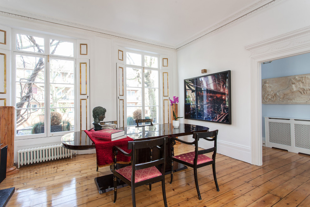 Medium sized classic dining room in London with white walls, medium hardwood flooring and brown floors.