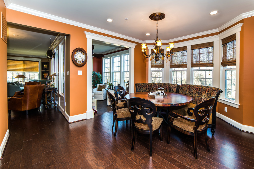Exemple d'une salle à manger ouverte sur la cuisine chic de taille moyenne avec un mur orange, parquet foncé, aucune cheminée et un sol marron.