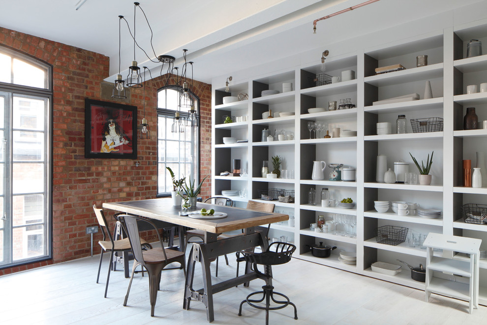 Inspiration for a large industrial dining room in London with painted wood flooring.