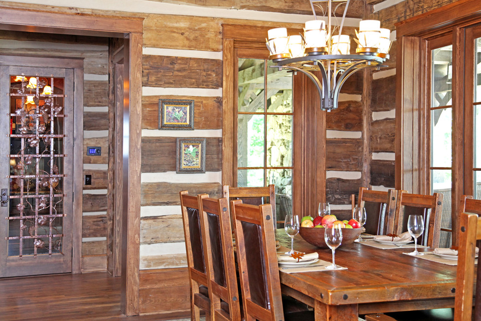 Immagine di una sala da pranzo aperta verso il soggiorno stile rurale di medie dimensioni con pareti marroni e parquet scuro