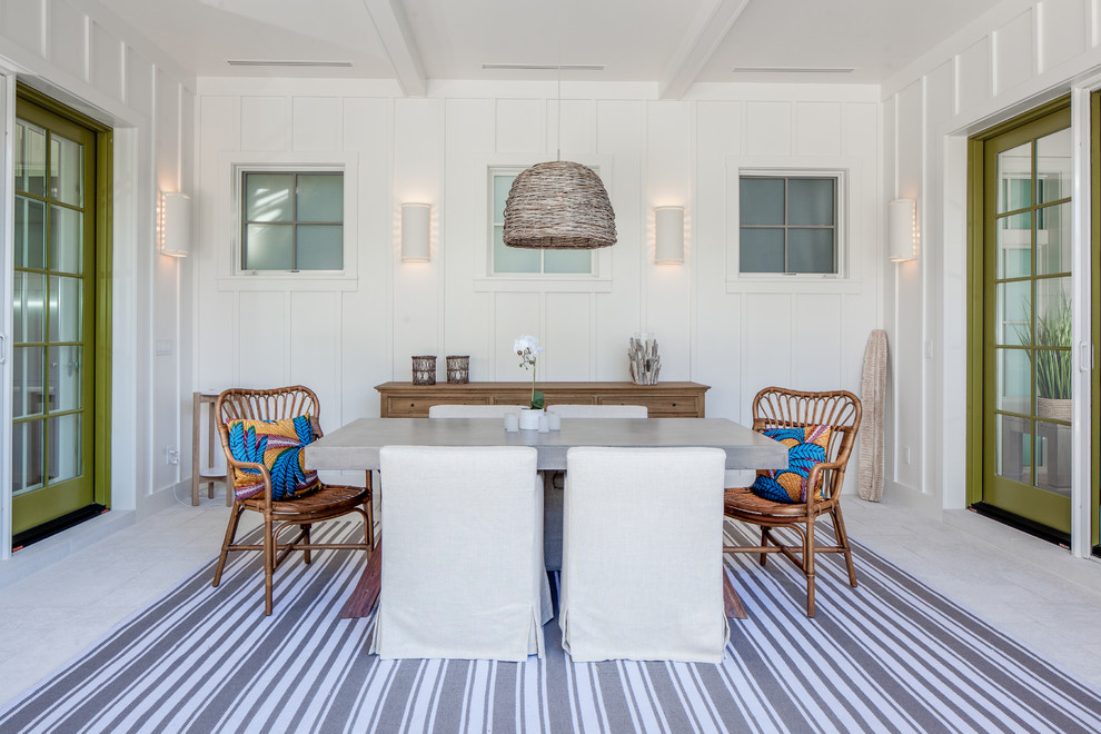 Immagine di una sala da pranzo costiera chiusa e di medie dimensioni con pareti bianche, pavimento in pietra calcarea e pavimento bianco