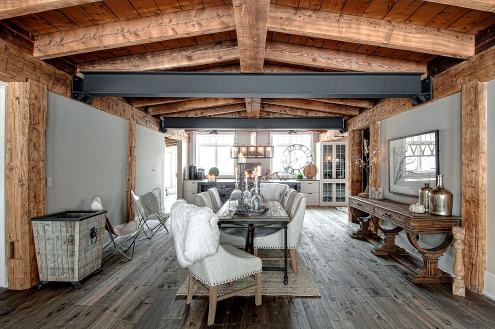 Immagine di una sala da pranzo aperta verso la cucina stile rurale di medie dimensioni con pareti grigie e pavimento in legno massello medio