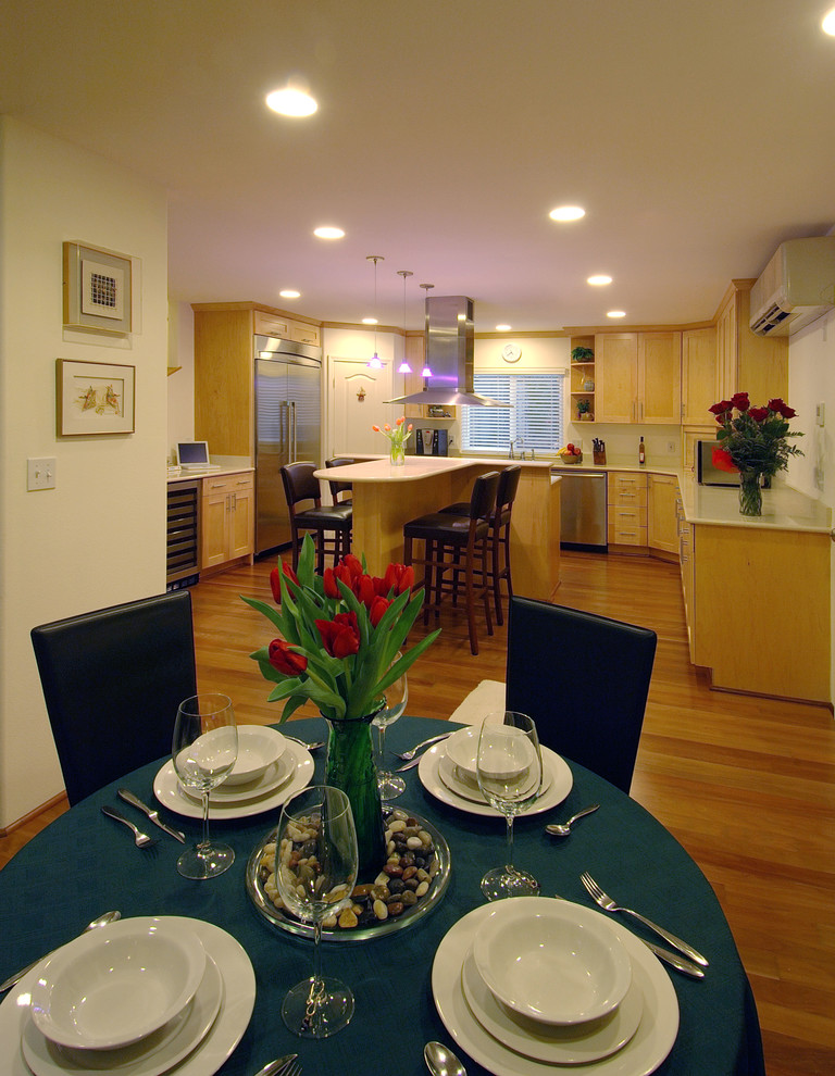 На фото: кухня-столовая в современном стиле с белыми стенами и паркетным полом среднего тона
