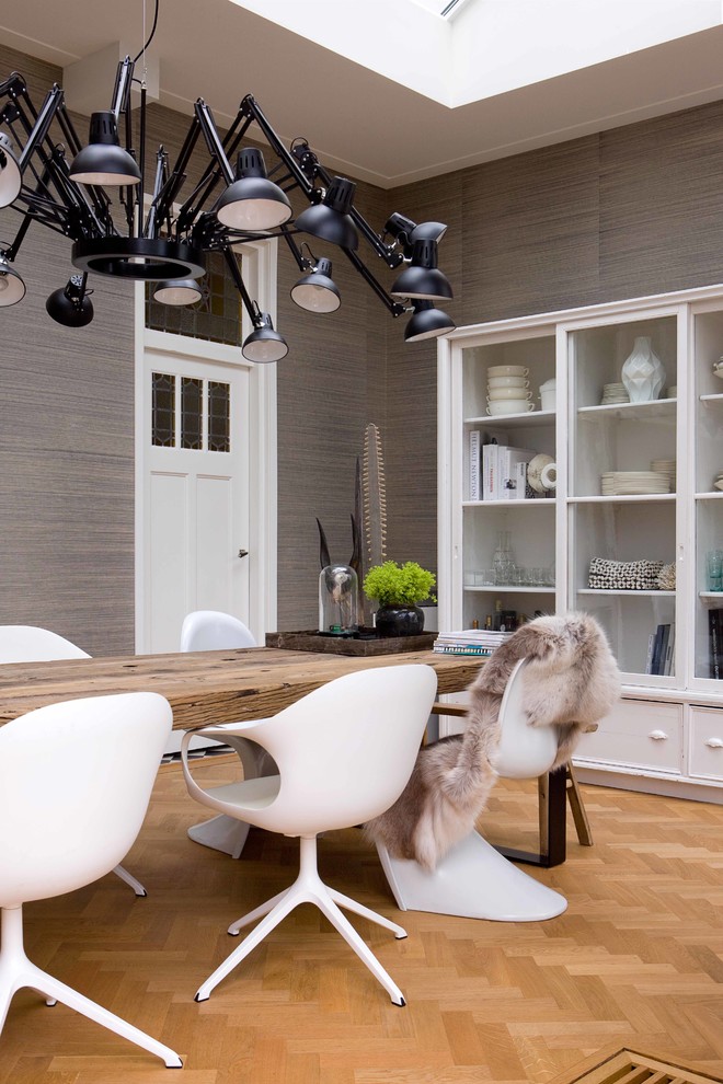 Modernes Esszimmer mit grauer Wandfarbe und braunem Holzboden in Amsterdam