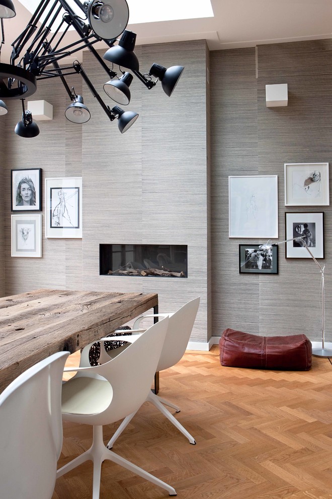 Immagine di una sala da pranzo minimal con pareti grigie e camino lineare Ribbon
