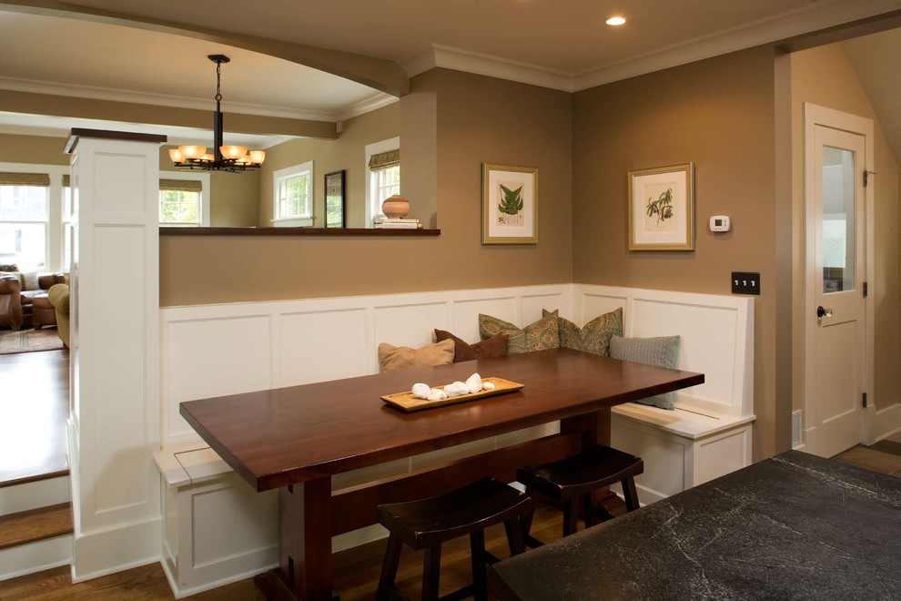 Foto di una sala da pranzo aperta verso la cucina classica con pareti marroni e parquet scuro