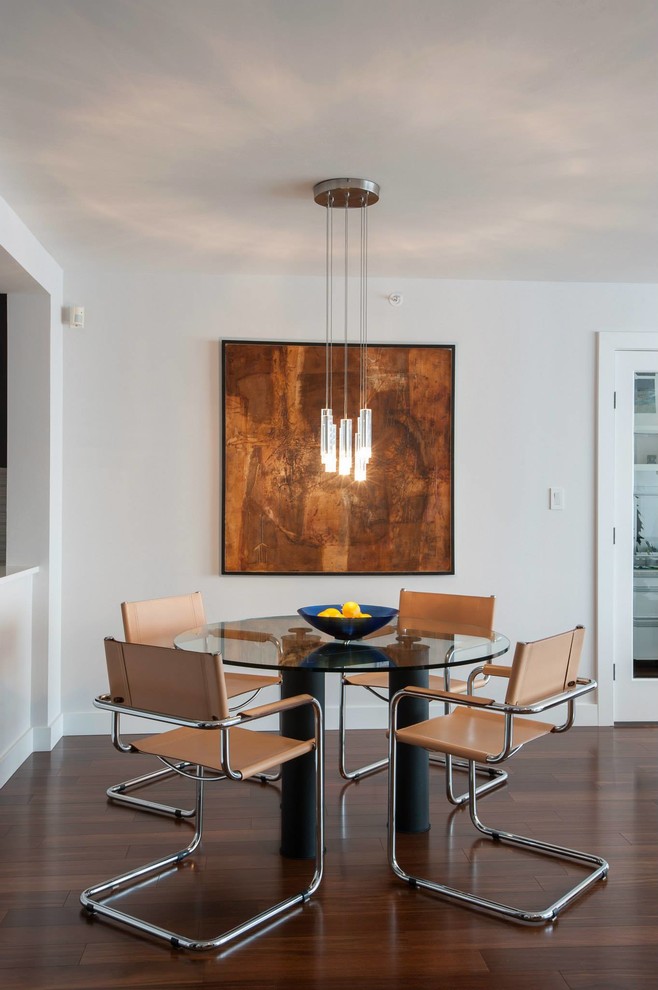 Immagine di una piccola sala da pranzo aperta verso il soggiorno minimal con pareti bianche e pavimento in legno massello medio