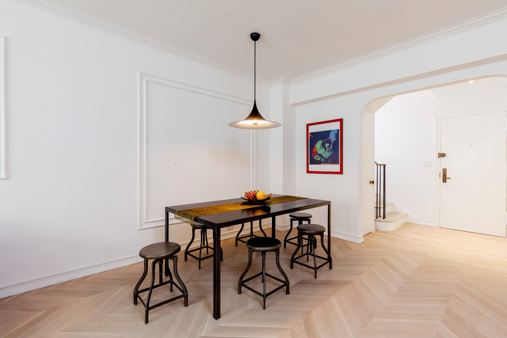 Cette image montre une salle à manger ouverte sur la cuisine design de taille moyenne avec un mur blanc, parquet clair et un sol beige.
